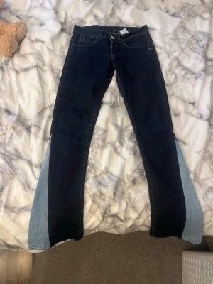 G-star jeans  - Unika mörkblå jeans med ljusblå paneler längs utsidan av benen. Byxorna är lågmidjade och i storlek 27, jag säljer byxorna då dom är för små och byxorna är i bra skicka knappt använda. Priset kan diskuteras.
