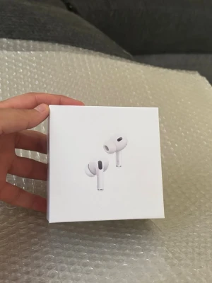 Apple AirPods Pro (2nd gen) hörlurar - Säljer ett par vita Apple AirPods Pro (2nd generation) med stilren design och laddningsetui. Trådlösa in-ear hörlurar med brusreducering och hög ljudkvalitet. Perfekta för musik, samtal och träning. Levereras i originalförpackning.