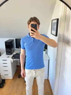 Blå pikétröja från Ralph Lauren - Snygg blå pikétröja från Ralph Lauren med klassisk krage och korta ärmar. Hör gärna av dig vid frågor!