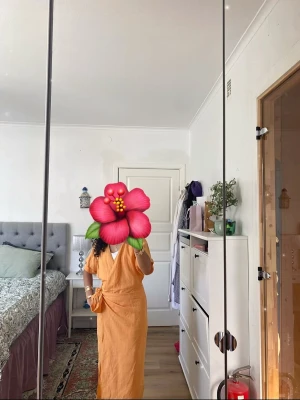 Orange wraparound klänning i bomull - Klänning i en orange färg med korta ärmar och knytskärp i midjan. Tillverkad i tunt, luftigt bomullstyg som känns skönt mot huden. Perfekt för en sommar. Använd fåtal gånger