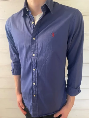 Blå skjorta från Ralph Lauren - Klassisk blå skjorta från Ralph Lauren.                   Skjortan är i jätte fint skick.                                                 Storlek M.                                                                               Fråga gärna om ni undrar något!