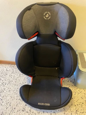 Maxi-Cosi bilbarnstol svart/grå - Säljer en svart och grå bilbarnstol från Maxi-Cosi med ergonomisk design och vadderade sidor för extra komfort. Stolen har justerbart nackstöd och sidokrockskydd. Passar till barn och är enkel att montera i bilen. Perfekt för säkra bilresor.