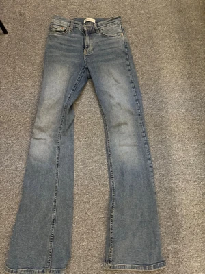 Blå bootcut jeans från Gina tricot - Säljer ett par klassiska blå bootcut jeans från Gina tricot. Jeansen har en snygg tvätt med raka och utsvängda ben. Perfekta till vardagslooken!