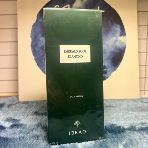 IBRAQ Emerald Soul Diamond parfym - Emerald Soul Diamond från IBRAQ är en Eau de Parfum i en elegant, mörkgrön rektangulär förpackning. Flaskan rymmer 150 ml och har en lyxig känsla med minimalistisk design och tydlig logotyp. Perfekt för dig som gillar exklusiva dofter och snygg förpackning.