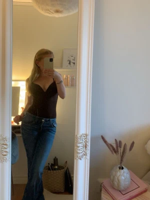 Lågmidjade jeans  - Säljer ett par klassiska blå bootcut jeans med hög midja och fem fickor. Jeansen har en snygg tvätt och sitter tajt över höfterna för att sedan bli vidare nedtill. Perfekta till en trendig vardagslook.