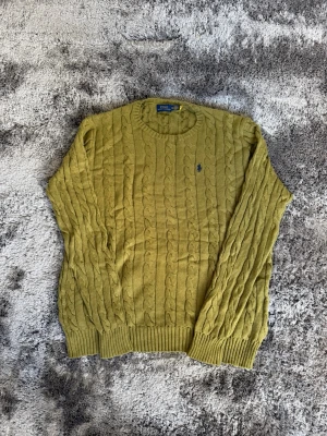 Olivgrön kabelstickad tröja Polo Ralph Lauren (XLT/ Extra large tall) - 💚 Ralph Lauren kabelstickad tröja Säljer denna superstirena, helt oanvänd kabelstickade tröja från Polo Ralph Lauren i en puderblå färg. Väldigt clean och enkel att styla till både jeans och cargos. Broderad logga på bröstet. ✨ Bra skick ✨ Mjuk och skön passform ✨ Perfekt för höst/vinter ✨ Storlek: Extra large tall. 