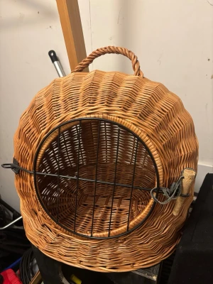 Flätad transportkorg för djur - Rund transportkorg i naturfärgad flätad rotting med svart metallgaller framtill och praktiskt handtag upptill. Perfekt för att bära smådjur som katt eller kanin. Korgen har en klassisk design och är lätt att bära med sig.