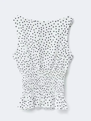 Vit prickig ärmlös topp - Säljer en söt vit topp med svarta prickar från Gina Tricot. Toppen har en smockad midja som ger en snygg passform. Toppen är ärmlös och har en liten volangkant nedtill för extra detalj. Perfekt för dig som gillar trendiga och lekfulla plagg. Använd några fåtal gånger 