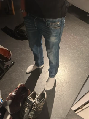 Blå Replay Grover straight fit jeans - Säljer ett par blå jeans från Replay, modell Grover med straight fit. Klassisk femficksdesign, snygga slitningar och kontrastsömmar. Tillverkade i denim med läderpatch bak i midjan. Perfekta för en avslappnad och trendig look.