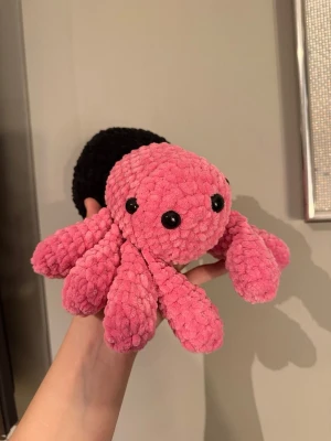 Mysig handvirkat gosedjur - Säljer en gullig spindel gosedjur i mjuk garn med rosa huvud och ben samt svart kropp. Spindeln har åtta ben och svarta plastögon. Perfekt som kramdjur!