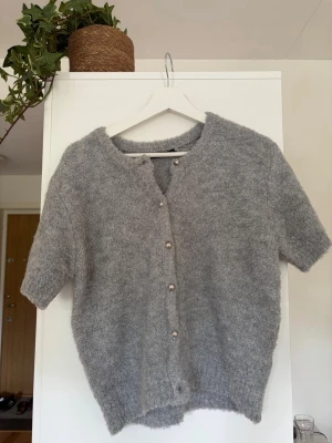 Grå stickad kofta/tröja GinaTricot  - En mjuk grå stickad tröja/kofta från GinaTricot i storlek S. Använd 2 gånger. Silver knappar. 