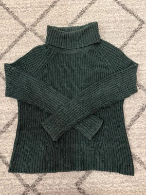 Mörkgrön polotröja från Jacqueline de Yong - Stickad mörkgrön polotröja från Jacqueline de Yong. Tröjan har en hög krage, lång ärm och grovstickad struktur som ger en mysig känsla. Super fin passform! Tryck inte på köp innan ni kontaktat mig! 