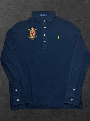 Vintage Polo Ralph Lauren långärmad pikétröja - herr strl L - Säljer en vintage marinblå Polo Ralph Lauren långärmad pikétröja i storlek L med brodering på bröstet  👕 Märke: Polo Ralph Lauren 📏 Storlek: L 🎨 Färg: Marinblå 🧵 Material: 100% bomull 📐 Mått: Längd 72 cm, bredd 55 cm 📍 Skick: Mycket fint skick (se bilder)  💬 Har du några frågor är det bara att höra av dig! 💰 Vid snabb affär kan priset diskuteras. 📦 Skickar alltid inom 24 timmar!
