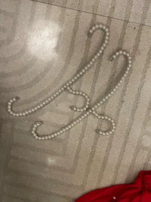 Pärlband håraccessoar i vitt - Det här är ett långt, böjbart hårband täckt med vita plastpärlor. Perfekt för att skapa kreativa frisyrer eller som en snygg detalj i håret. Materialet är plastpärlor på metalltråd och färgen är klassiskt vit.