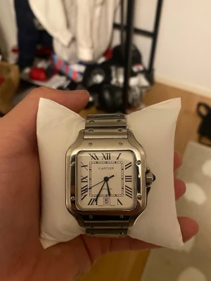Carti Santos Klocka  - Säljer en klocka som har små repor på bezeln men ej länkarna, väldigt bra kondition, kommer med allt, bara lite dammig då ja ej använder den men annars perfekt, vattentät i 100M