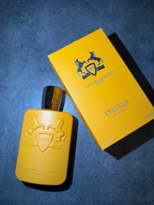 Parfums de Marly Perseus EdP 125ml - Parfums de Marly Perseus Eau de Parfum i en matt gul flaska med elegant reliefmönster och svart kork. Flaskan har märkets ikoniska hästar och sköld, och kommer i en matchande gul kartong. Lyxig och modern design som sticker ut i parfymhyllan. Kvitto finns!!!!