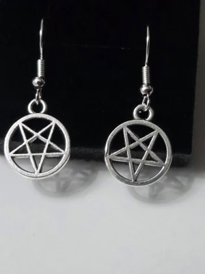 Pentagram Örhängen i Rostfritt Stål - Snygga och stilrena örhängen med pentagram-berlocker. Eftersom de är tillverkade i rostfritt stål håller de sig fina över tid utan att mörkna eller färga av sig, och är dessutom snällare mot huden. Perfekta för dig som gillar en alternativ, goth eller personlig stil. ​Helt nya och aldrig använda! ​Detaljer: ​Material: Rostfritt stål (Stainless Steel) ​Färg: Silver ​Mått: Ca 1.4 cm 