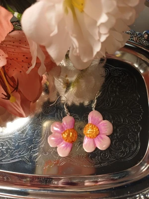 Blommor örhängen - Handgjorda örhängen med blommor Schimriga blommor One of a kind Denna är Handgjord av lera därav priset. Om intresse fins kan jag göra flera
