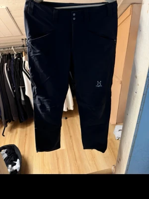 Svarta byxor från Haglöfs - svarta byxor från Haglöfs med raka ben och två dragkedjeförsedda fickor framtill. Tillverkade i slitstarkt material som passar perfekt