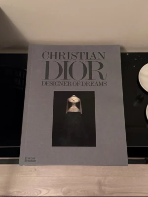 Dior Coffe Table Book - Christian Dior Designer Of Dreams✨ Stor Coffe Table Book Perfekt i ett bokstöd. Finns små repor  Nypris 1199 SEK på Newport Länk:  https://www.newport.se/shop/inredning/coffee-table-books/modebocker/christian-dior-designer-of-dreams?utm_source=google&utm_medium=cpc&utm_campaign=17551314469&utm_content=&utm_term=&gad_source=1&gad_campaignid=17559042875&gbraid=0AAAAADk85Jx7JMVzI9Izk_vWVJQgqAWWg&gclid=Cj0KCQiA4pvMBhDYARIsAGfgwvwq7bK73MTqoiJS66FwT6tKEu7VjAAT8_OsE3xC-WnFDYkKkL0NyJwaAvYPEALw_wcB