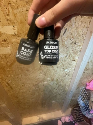 JIAZHICAP Base & Glossy Top Coat - Två flaskor nagellack från JIAZHICAP: en Base Coat och en Glossy Top Coat. Båda är soak-off UV/LED och kommer i svarta flaskor med vit text, 18 ml vardera. Perfekt för att skapa en hållbar och glansig manikyr.