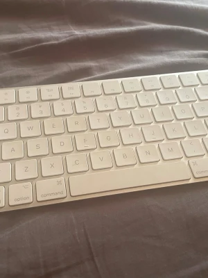 Apple Magic Keyboard vit - Säljer ett Apple Magic Keyboard i vit färg med låg profil och slimmad design. Tangentbordet är trådlöst och har svenska tangenter. Tillverkat i plast och aluminium, perfekt till Mac-datorer.