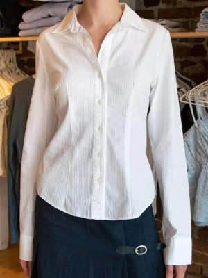 Millie Stripe Top - Brandy Melville  - Säljer den populära Stripe Skjortan Millie från Brandy Melville i one Size (skulle säga strl XS-S) Formar kroppen superfint och galen att styla med oknäppt eller knäppt! Använt på 2 studentfiranden! Frågor? Kom DM! 