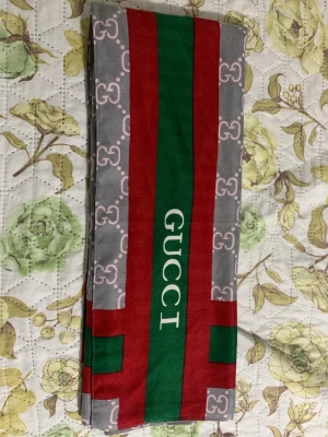 En fin Scarf  - Snygg Scarf med klassiskt logomönster i ljusrosa på grå botten. Använd sparsamt. Ej äkta. 