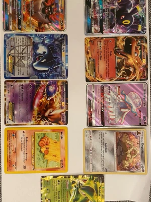 Pokémonkort blandade GX och EX - Säljer ett gäng Pokémonkort med blandade motiv, inklusive GX, EX och vanliga kort. Flera holografiska och färgglada kort med olika Pokémon som Vulpix, Virizion och Ninetales. Korten är av papp och har klassisk rektangulär form, perfekt för samlare eller spelare.