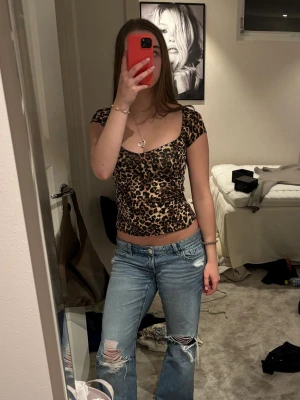 Leopardmönstrad croppad topp - Trendig croppad topp med leopardmönster och korta ärmar. Snyggt figurnära passform och fyrkantig ringning. 