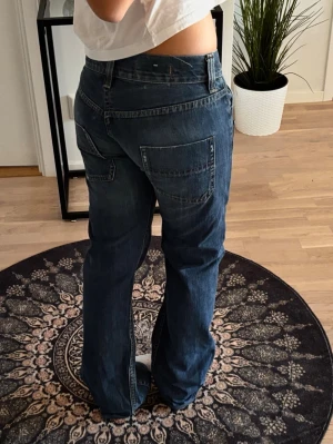Riktigt snygga jeans  - Säljer ett par blå cargojeans med raka ben och stora fickor både fram och bak. Jeansen har en avslappnad passform och klassisk denimlook, perfekta för en trendig och casual stil. Materialet är kraftig bomullsdenim. Köptes dyrt secondhand.