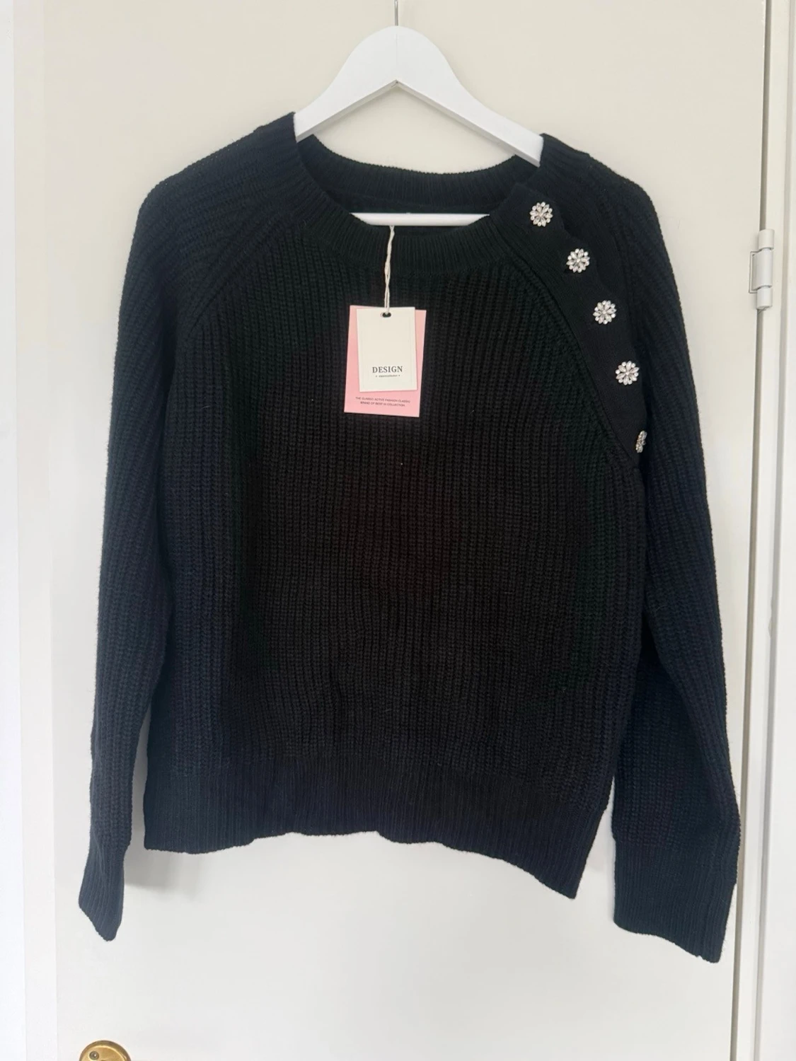 Svart stickad tröja med blommiga knappar