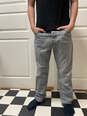 Jack n Jones ljusgrå jeans, storlek 32/32 - Klassiska Jack n jones jeans i en ljusgrå tvätt. Rak passform med knappgylf och femficksdesign. Perfekta för dig som gillar en tidlös och avslappnad stil. Tillverkade i slitstarkt jeanstyg.