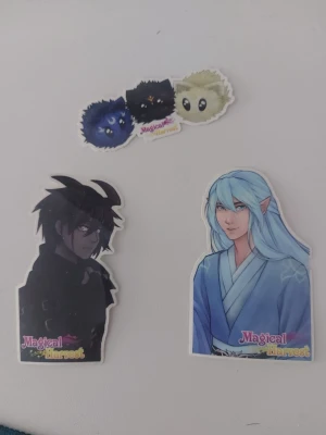 Magical Harvest animeklistermärken - Tre klistermärken från Magical Harvest med animeinspirerade motiv: en siluett av en karaktär, en figur med långt blått hår och alvöron i blå kimono samt ett klistermärke med tre fluffiga djur i olika färger.