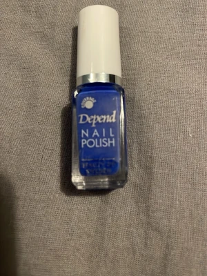 Blått nagellack från Depend - Snyggt blått nagellack från Depend i en liten glasflaska med vit kork. Perfekt för dig som vill ha en färgstark och trendig look på naglarna. Lätt att applicera med den smidiga borsten och ger ett jämnt resultat.