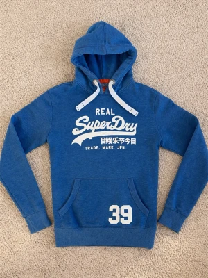 Superdry Hoodie - Snygg blå hoodie från Superdry. - Hör av er vid frågor. - Storlek: M men sitter närmare S - Pris: 549kr. - Först till Kvarn!!!