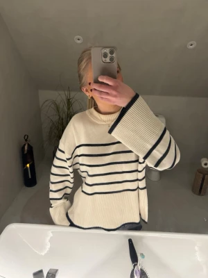 Randig stickad tröja med vida ärmar - Krämvit stickad tröja med svarta ränder och vida ärmar. Storlek S. Superfin💕