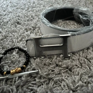 Vitt H bälte  - Säljer mitt herrmes bälte 115cm helt nytt. Armband ingår. Hör av er vid frågor och funderingar 