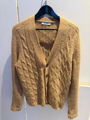 KASHMIRCARDIGAN FRÅN GRAN SASSO - Beige kabelstickad Kashmir cardigan från Gran Sasso. Storlek 48/M. Skönt material och snygg passform. Passar bra i flera tillfällen. Riktigt bra skick. Hör av er vid flera frågor, Walter.