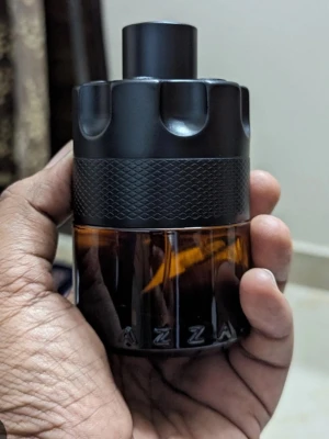 Azzaro parfym  - Cool parfymflaska från Azzaro med en unik, rund design. Flaskan har en mörkbrun, nästan svart glasbotten och ett mattsvart lock med greppvänlig struktur. Perfekt för dig som gillar stilrena och maskulina dofter. sprejat de  ungefär 20 gånger