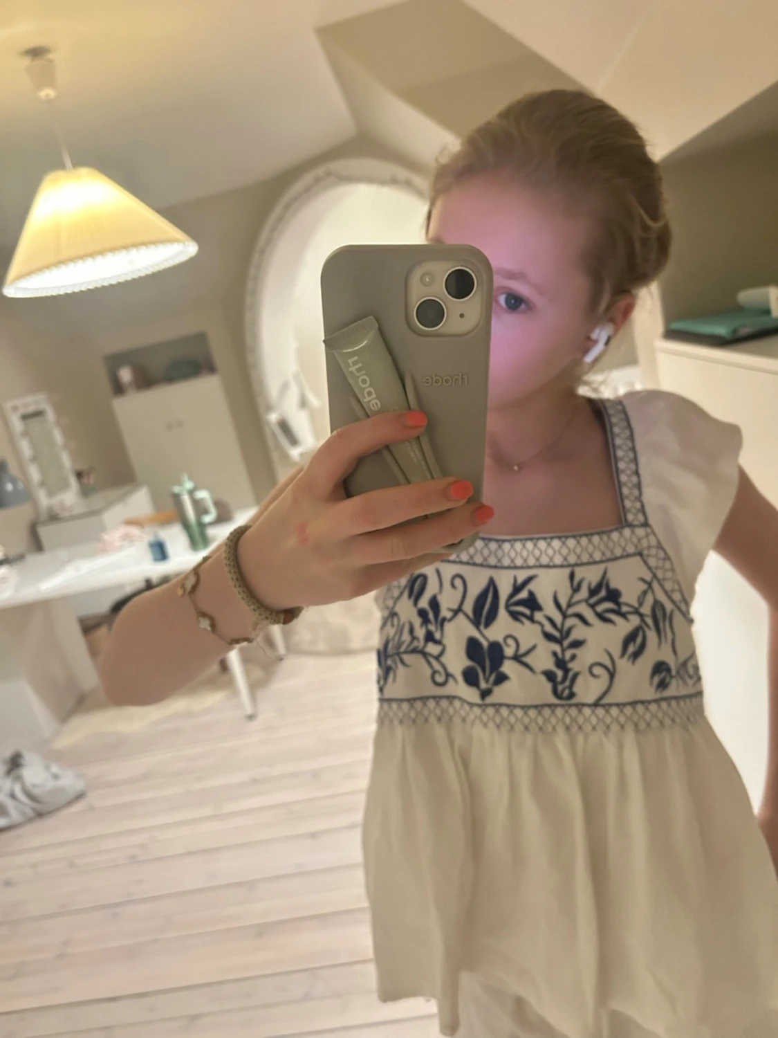 Vit blus med blå broderi