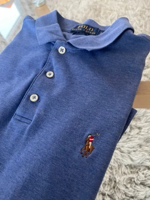 Polo Ralph Lauren Piké - Fin Pikétröja i mjukt material  Skick: Utmärkt, inga skador eller skavanker såsom hål eller fläckar.  Mått: • Axel - Axel: 43cm • Axel - Midja: 59cm • Armhåla - Armhåla: 46cm • Axel - Ärmslut: 20cm  Detaljer • Tillverkad i 100% Bomull • Mycket mjukt och lent material • Broderad logga på vänster sida av bröstet • Luktfri  Nypris: 1595kr - Mitt Pris: 349kr Skickas inom 24 timmar efter köp! 