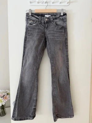 Grå bootcut jeans med fickdetaljer - Snygga grå jeans med bootcut passform. 