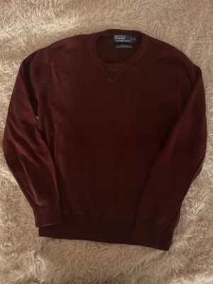 Vinröd Ralph Lauren tröja - Snygg och unik vinröd stickad tröja från Ralph Lauren. Rare find! Gammal modell, säljs inte längre. Så passa på!! Lite nopprig med tanke på åldern men annars bra skick utan defekter. postar inom 24h! köp mer än ett plagg för 10% rabbat🤝Tveka inte på att höra av er vid funderingar!