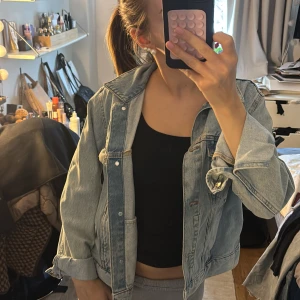 Ljusblå oversized jeansjacka - Trendig ljusblå jeansjacka i oversized modell med klassisk krage och knappstängning framtill. Två bröstfickor med knapp, så snygg! Till hösten eller våren.