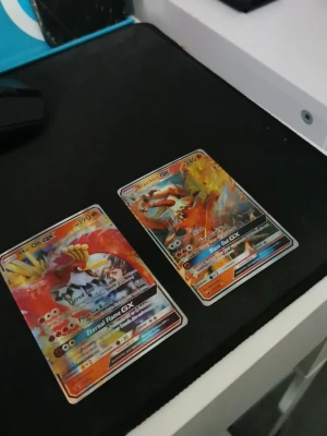 Pokémon GX-kort Ho-Oh & Blaziken - Två Pokémon GX-samlarbilder: Ho-Oh GX och Blaziken GX. Båda korten har färgstarka illustrationer med holografisk effekt och detaljerade attacker. Perfekt för dig som gillar att samla eller spela Pokémon TCG.