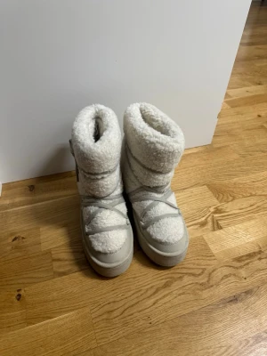 Vita fluffiga  boots med snörning - Säljer ett par vita  boots med fluffigt teddy-material och grov sula. Från hm