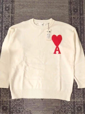 Vit stickad tröja från Ami Paris - Väldigt snygg tröja, priset ksn diskuteras och skickar direkt efter köpet. Passar både män och kvinnor 