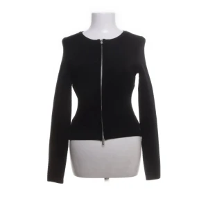 Svart figurnära kofta från Hugo boss  - Stilren svart kofta med figurnära passform och lång ärm. Koftan har en silverfärgad dragkedja framtill som går hela vägen upp till den runda halsringningen. Storlek s