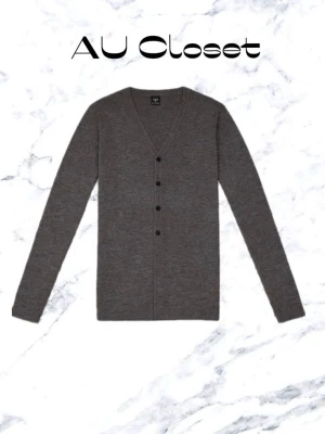 Grå kofta med knappar f - Klassisk grå kofta med v-ringning och svarta knappar framtill. Tillverkad i mjukt, ribbstickat material och har lång ärm. Perfekt för lager på lager och enkel att matcha med olika outfits.